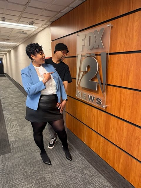 Strengthening Solutions founder Twanda Lane pointing to the FOX 2 News sign at the Detroit studio.